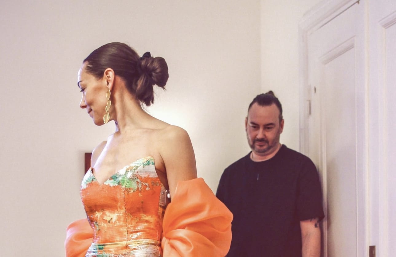 Tiia Törrö sovittaa juhlamekkoaan Helsingissä. Kuvassa myös suunnittelija Jukka Puljujärvi.