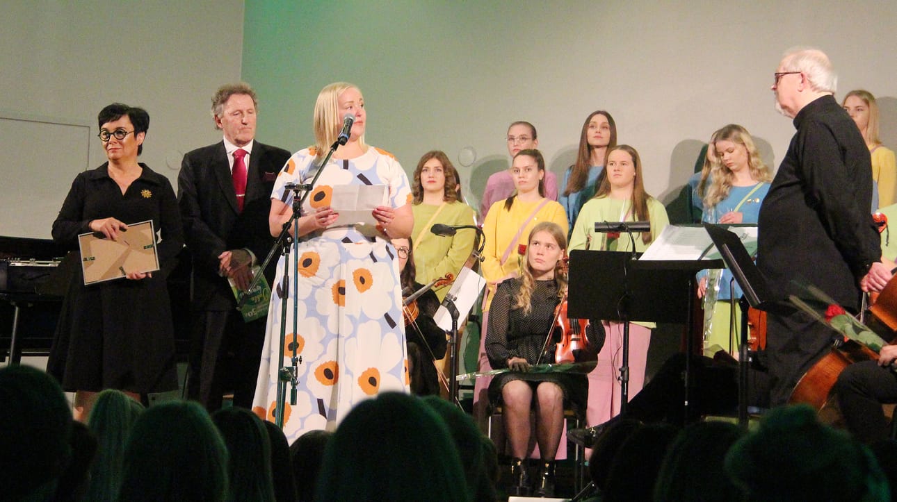Kaupunginjohtja Riikka Moilainen, valtuuston puheenjohtaja Kai Pajala ja kaupunginhallituksen puheenjohtaja Marjut Lehtonen paljastivat musiikkineuvos Tapani Tirilälle Oulaisten kaupungin lahjan: Merkuriussalin nimen muuttamisen Tirilä-saliksi sekä tilan monipuolistaminen kulttuurikäyttöön.