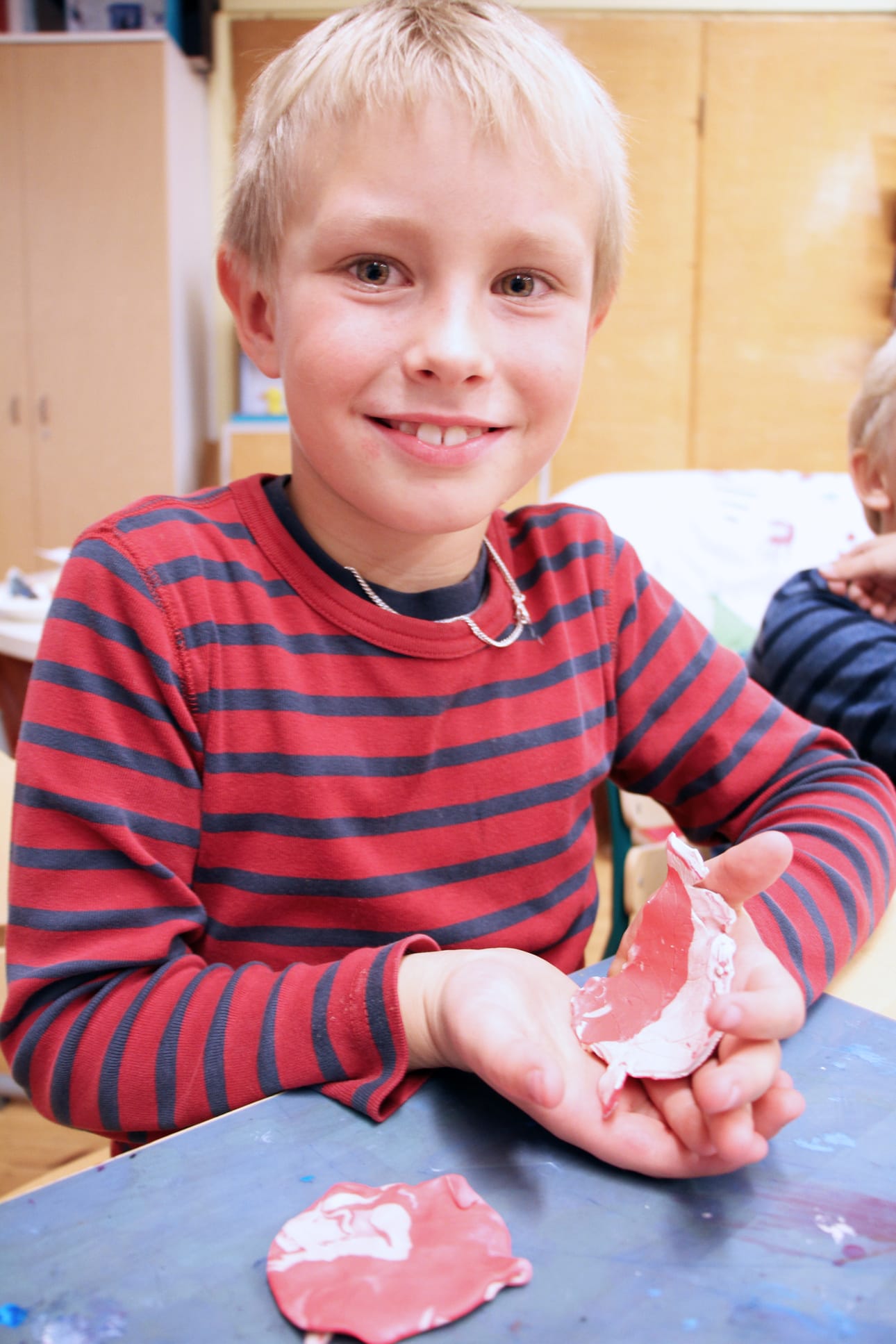 Santeri Pietilä askarteli lehteä kyläillan askartelupajassa. Uunipolton jälkeen nuori taiteilija sai teoksen mukaansa kotiin.