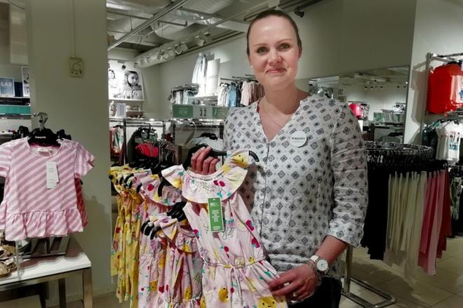 KappAhlin myymäläpäällikkö Taija Lappalainen näyttää, miten ekologisesti tuotetun vaatteen voi tunnistaa. kuvat: anni loukasmäki
