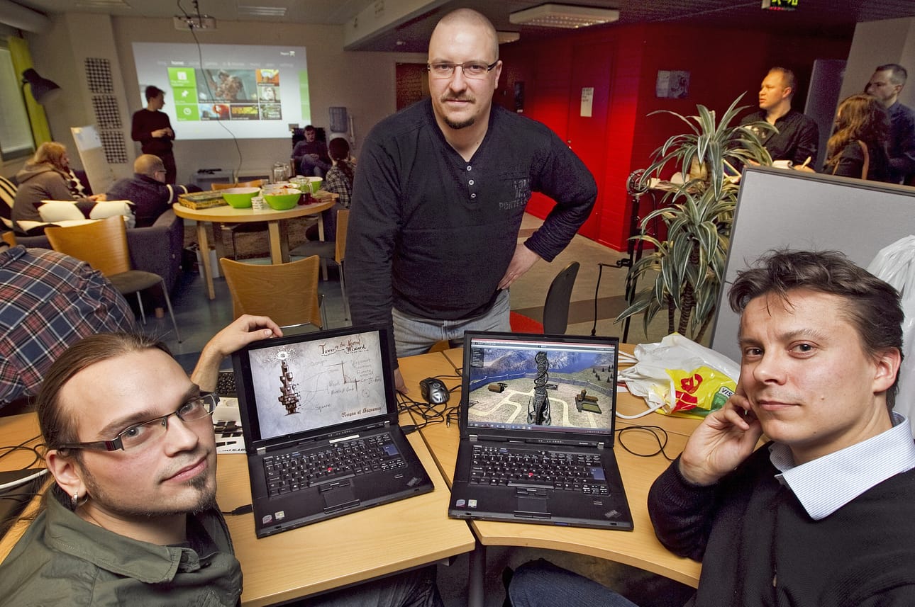 Petri Naumanen, Pekka Karjalainen ja Veijo Härkönen kehittelevät Helmeni Gamesin ensimmäistä peliä. Vasemman puoleisessa näytössä on hahmotelma tornista, joka on päätynyt oikean puoleisessa näytössä kivitorniksi keskiaikaa henkivän pelin prototyyppiin.