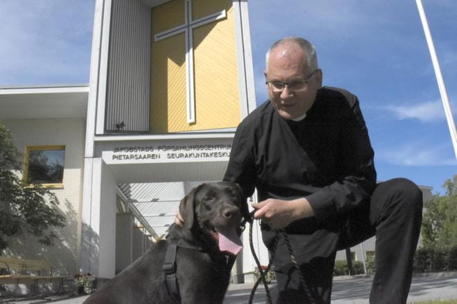 Kuvateksti: Bo-Göran Åstrand on Pietarsaaren ruotsalaisen seurakunnan kirkkoherra. Hän oli järjestämässä viime kesänä muun muassa koiranulkoiluttajien jumalanpalvelusta Pietarsaaressa. Kuvassa mukana labradorinnoutaja Doris. Kuva: Tapio Lehtinen