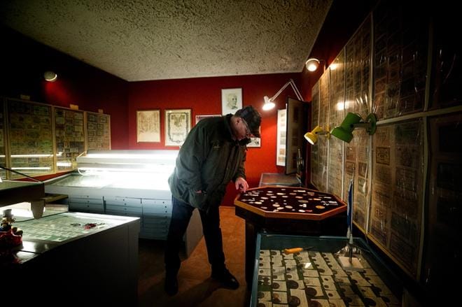 Martti Koskenkorva siirtää Arvo Haaviston mitaleita vitriiniin. Koskenkorvan tuoreessa ilmajokelaisista suojelusjoukoista kertovassa romaanissa Haaviston mainitaan ehdottaneen joukolleen painimista lämmön ylläpitämiseksi. – Kukaan ei halunnut painia Arvon kanssa, koska hänellä oli niin rajut otteet, Koskenkorva paljastaa. KUVAT: JAAKKO ELENIUS