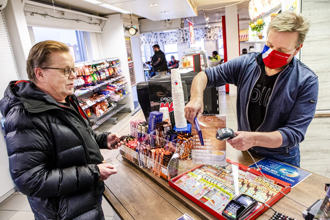 Jarmo Vilander on sekä autoilija että Teboilin kanta-asiakas toisessa polvessa. Kanta-asiakkaiden suosikkipöydät näkyvät taustalla, isompi kahvilasali on talon toisessa päässä. Tiskin takana palvelee yrittäjä Kari Vallo.
