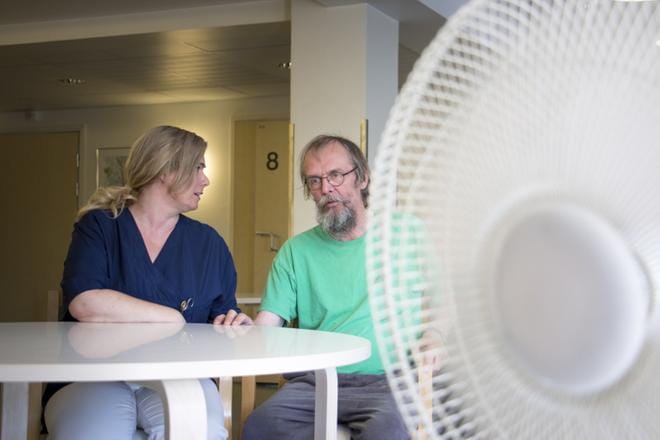 Ani Raunio ja Erkki Hannula vaihtavat päivän kuulumisia Vaasan keskussairaalassa. Tuuletin tuo hieman viilennystä iltapäivän kuumuuteen. KUVA: HANNU TOIVONEN