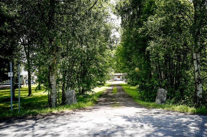 Portinpielikivet seisovat samalla paikalla, missä ne olivat noin sata vuotta sitten. Tien päässä näkyy seurakunnan entinen kerhorakennus. Vielä jokin aika sitten kuvasta vasemmalle oli lyhyt rivi kookasta ja vanhaa kuusiaitaa, joka oli todennäköisesti vanhan pappilan peruja.