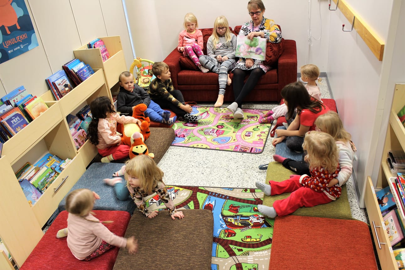 Karijoen esikoulun ja päiväkodin lapset kuuntelivat satutuntia kirjastossa. Sohvalla Anna-Maija Haaranojan kanssa ovat hänen lapsenlapsensa Enna Salimäki, 7, ja Elle Salimäki, 10. Tällä kertaa Elle luki satua ääneen. Seinäjokelaiset siskokset olivat viettämässä syyslomaa Karijoella.
