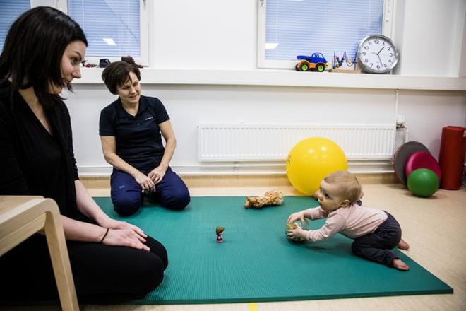 Itäkeskuksen perhekeskus yhdistää useat lapsiperheiden tarvitsemat sosiaali- ja terveyspalvelut yhden katon alle. Siiri Leppänen, pian 9 kuukautta, on toista kertaa fysioterapeutti Pia Hutrin luona. Äiti Katri Tuominen seuraa vierestä. Kuva: Joel Maisalmi