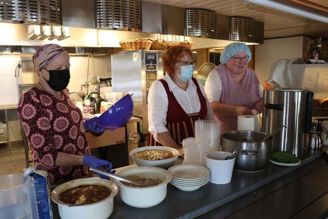 Perinneruokaa tapahtumaa varten laittoivat Katariina Yli-Hynnilä (oikealla) ja Tuula Latomäki (keskellä). Kiireessä auttamassa oli myös Tarja Suokonautio. Vasemmanpuoleisessa kulhossa on kaljavelliä ja heti sen vieressä oikealla piimävelliä. Kuva: Vilja Vainio