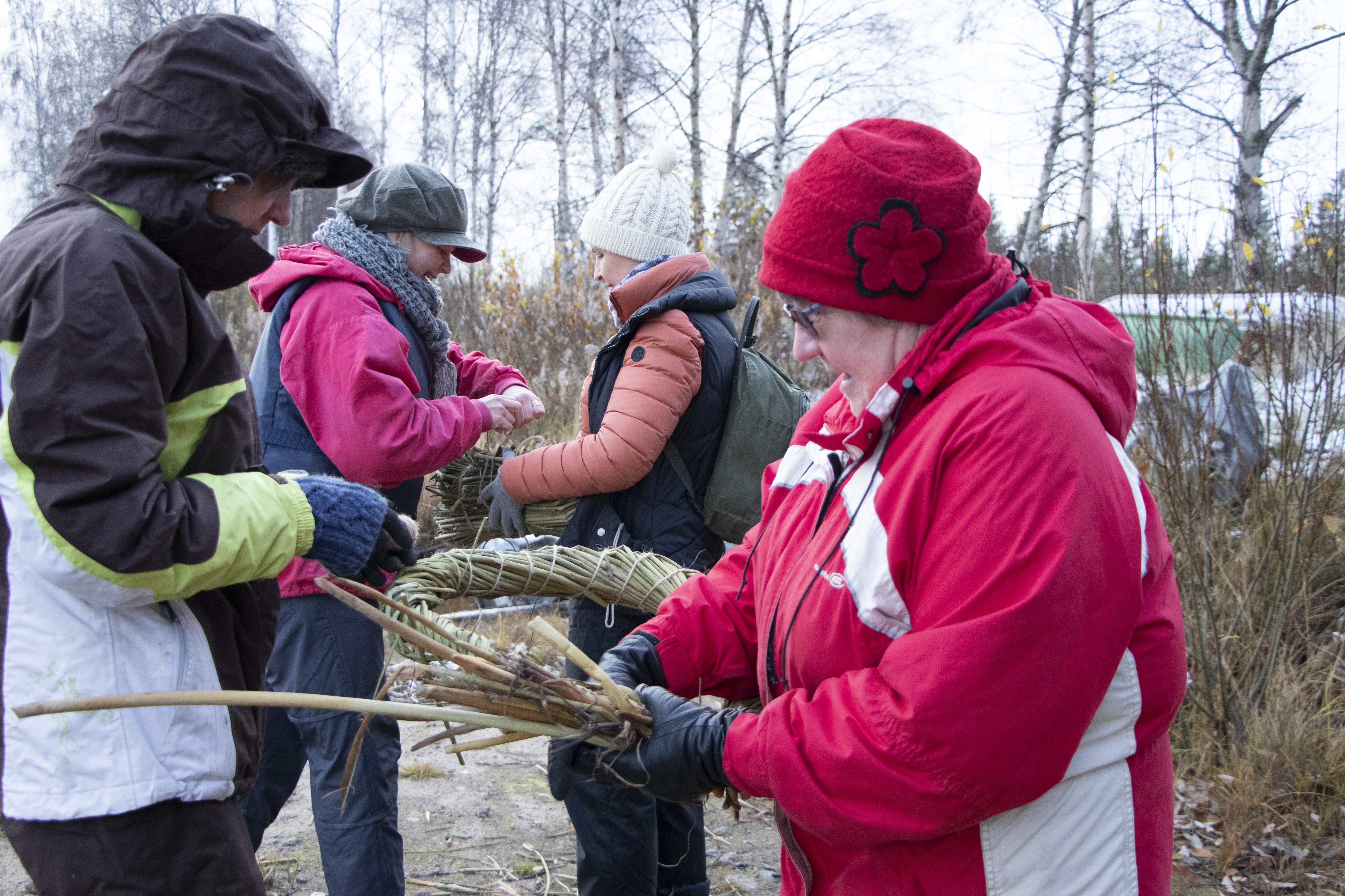 Etualalla Kaarina Konola ja Annikki Oikarinen sitoivat pelastusrengasta. Taustalla Rita Porkka ja Johanna Riepula tekivät kaislatyynyn kaislaveneen pohjalle.