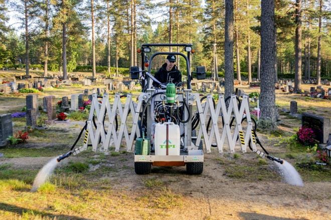 Timo Hyvösaho havainnollistaa TIPI-kastelulaitteen kakkosversion kykyä ruiskuttaa vettä samanaikaisesti molemmilta puolilta. KUVA: AARRE LÖYTÖMÄKI