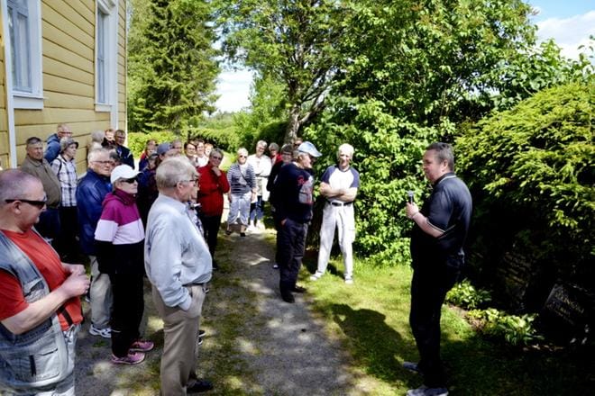 Jari Mäenpää (oik.) sai ympärilleen kolmisenkymmentä kuulijaa hautausmaakävelylle, joka oli Ränkiviikon ensimmäinen tapahtuma maanantaina. KUVA: MARKKU TURPELA