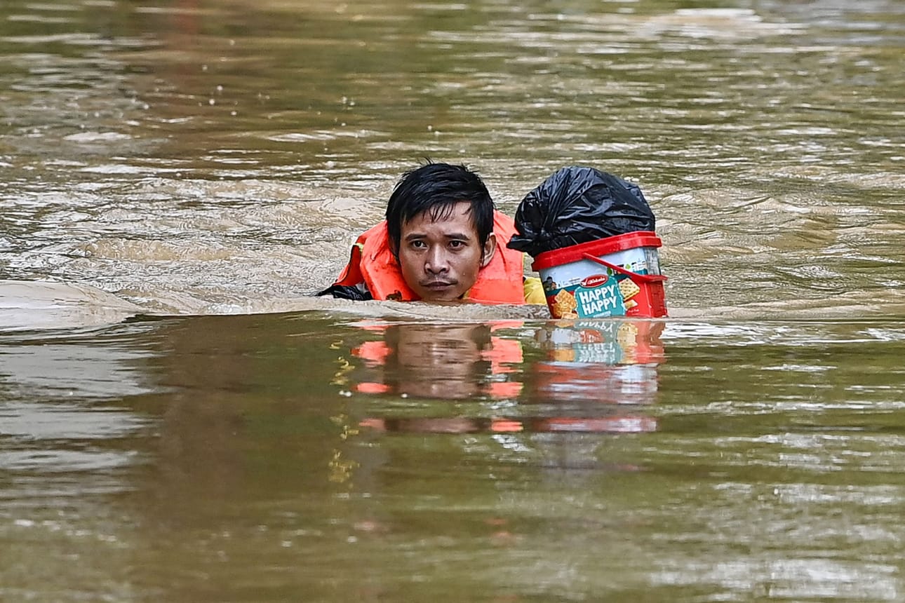 Mies ui tulvivalla kadulla Hanoissa Vietnamissa tiistaina. LEHTIKUVA/AFP