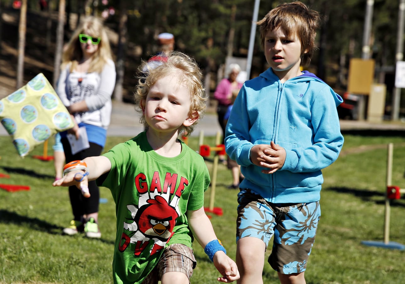 Oskari Hirvaskari, 4, (vas.) näyttää mallia, miten hernepussi lentää maaliin. Konsta Pernu, 7, odottelee innoissaan omaa vuoroaan.