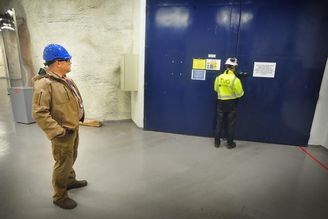 Tämä ovi avataan kerran vuodessa tai puolessatoista, kun jätettä viedään välivarastoon tai siirretään seiltä siiloihin. Petri Smolander (vas.) sanoo, että loputkin valtion jätteistä on tarkoitus tuoda tänne lähivuosina.