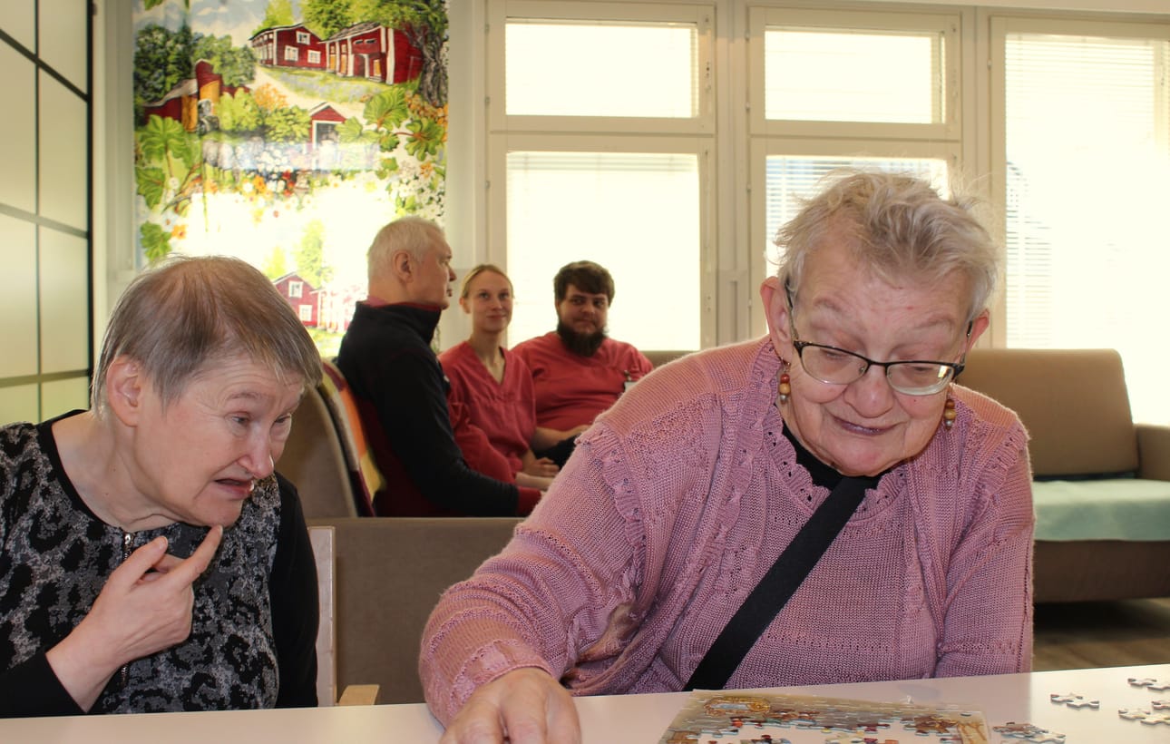 Tarja Kärki Kärjenkoskelta ja Anni Uusitalo Kirkonkylästä kokoavat palapeliä. Taustalla vesijärveläinen Tapio Kaukoranta juttelee Jenniina Lehtikevarin ja Jani Knuuttisen kanssa.
