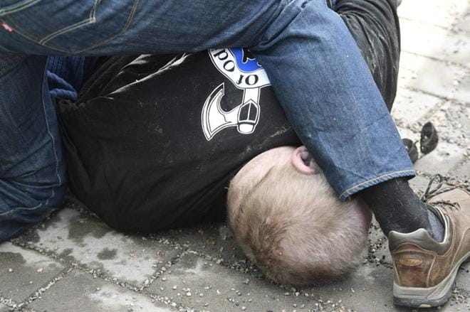 Turvamiehet painoivat maahan Soldiers of Odin -tunnuksiin pukeutunutta miestä, joka yritti lyödä ulkoministeri Timo Soinia. Kuvat: LEHTIKUVA / HEIKKI SAUKKOMAA