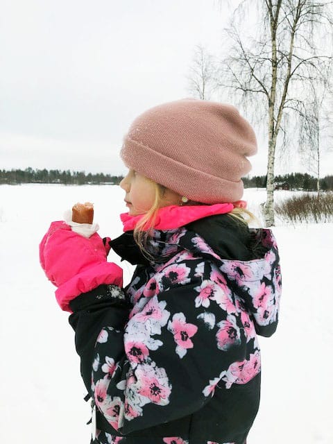 "Tässäpä kuva koululaisten talvilomalta. Tyrnävältä lähdimme vähän pohjoisemmaksi etsimään kunnon talvea, Pudasjärvellä lunta riittää ja Iijoki on jäässä! Kuvassa Hilla, 7, ja itse nuotiolla paistettu makkara."