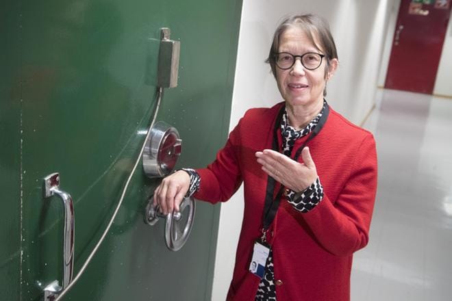 Erikoisasiantuntija Maritta Korhonen näyttää, että tämän vihreän, pankkiholvin ovea muistuttavan sisäänkäynnin taakse tullaan arkistoimaan hyllymetreittäin vanhoja, paperisia potilaskirjoja. Kelan arkistointitilat sijaitsevat Helsingissä, mutta kaikki Kelan työntekijätkään eivät tiedä, missä ne tarkalleen ovat. KUVA: Mauri Ratilainen