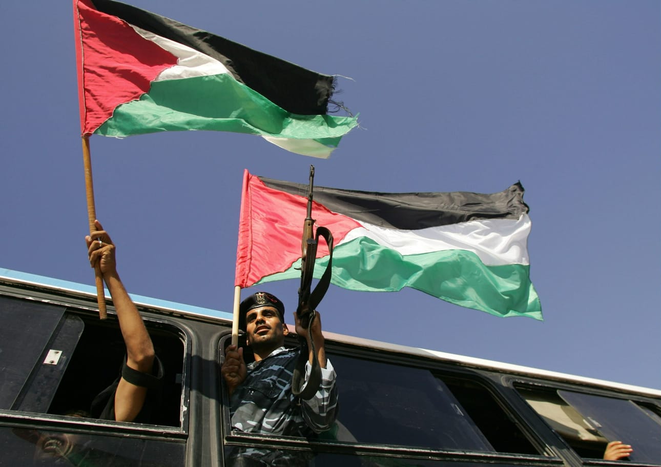 Palestiinan valtio on toistaiseksi olemassa enemmän tavoitteena kuin konkreettisena valtiona. Arkistokuvassa palestiinalainen poliisi heiluttaa Palestiinan lippua Gazan kaistalla. LEHTIKUVA/AFP