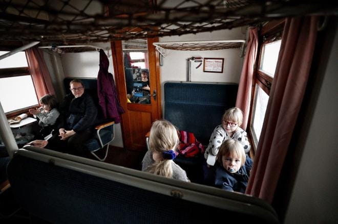 Kun juna lähti liikkeelle, oli lapsilla kiire ikkunoille. Juha Halmesmäen ja Satu Luomansuun perhe muisteli matkalla isovanhempiakin. KUVAT: TOMI KOSONEN