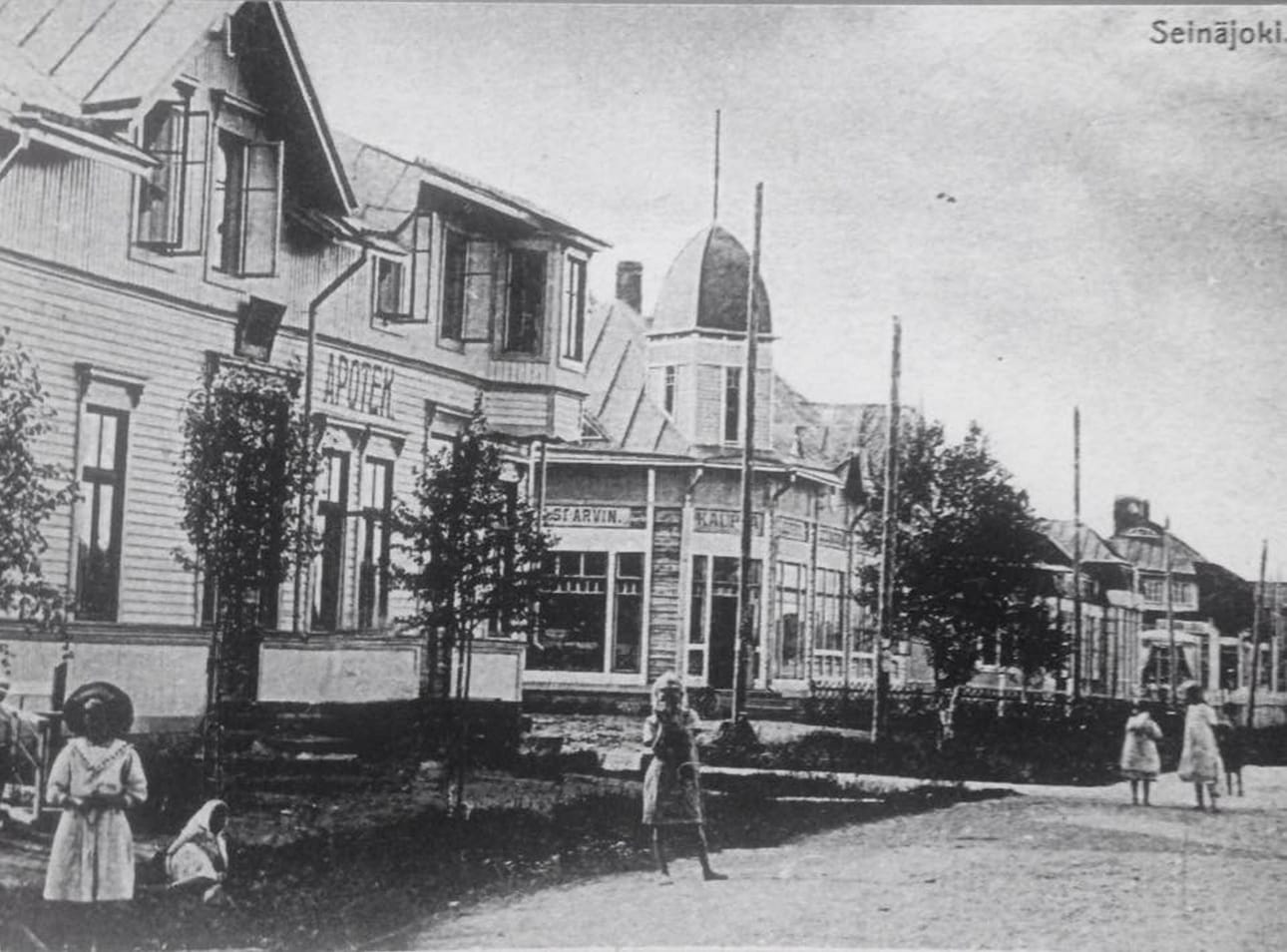 Ihastuttavin kuva vanhasta Seinäjoesta pikkutyttöineen: Valtiokatua 1910-luvulla. Talorivissä ovat apteekki, Sparvinin kauppa, Yhdyspankin talo ja Nygrenin kauppa. Kadun toisella puolen on aseman aluetta.