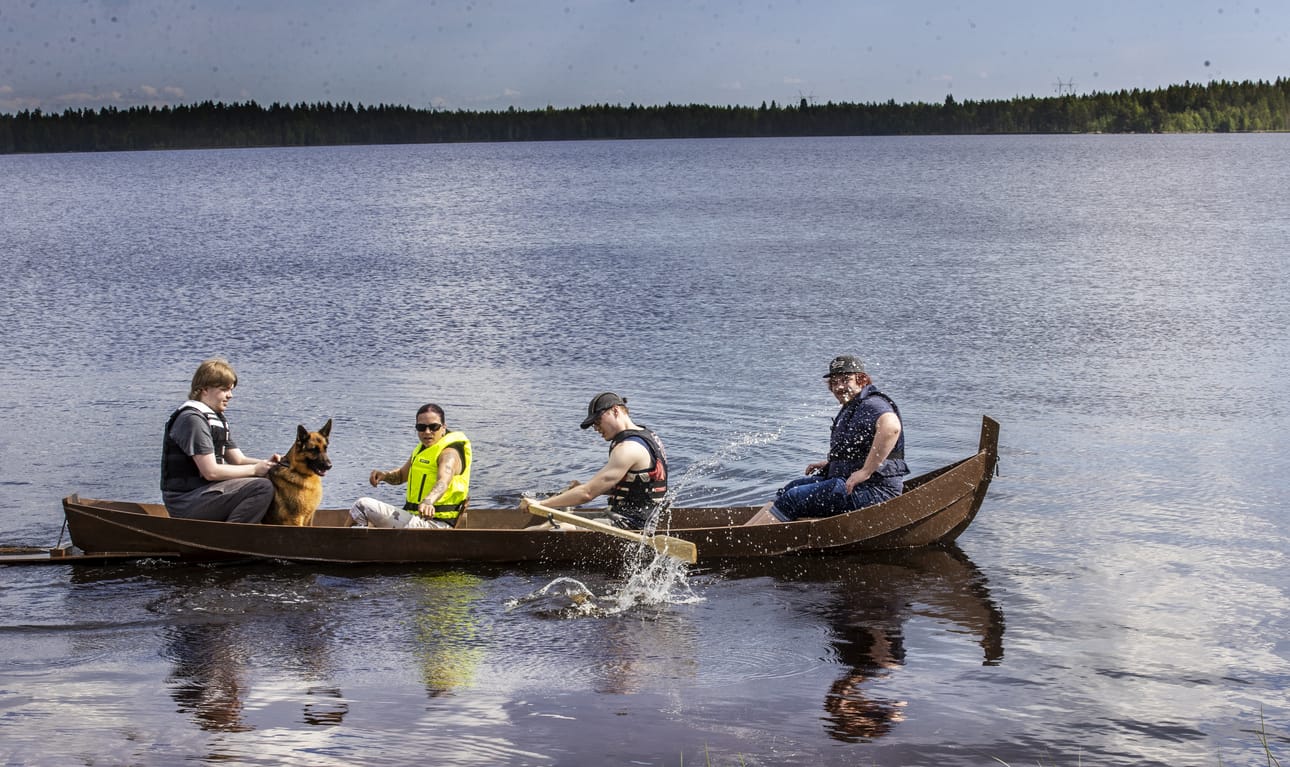 Miika Kauppi, saksanpaimenkoira Piitu, ohjaaja Petra Särkilä, Ville Turunen sekä Teemu Ventelä testaamassa ensimmäistä kertaa Tyrnävän nuorisopajan yhdessä tekemää venettä. Veneen rakentamisen kautta nuoret voivat kokea onnistumisen tunteita huomatessaan työnsä olleen merkityksellistä.