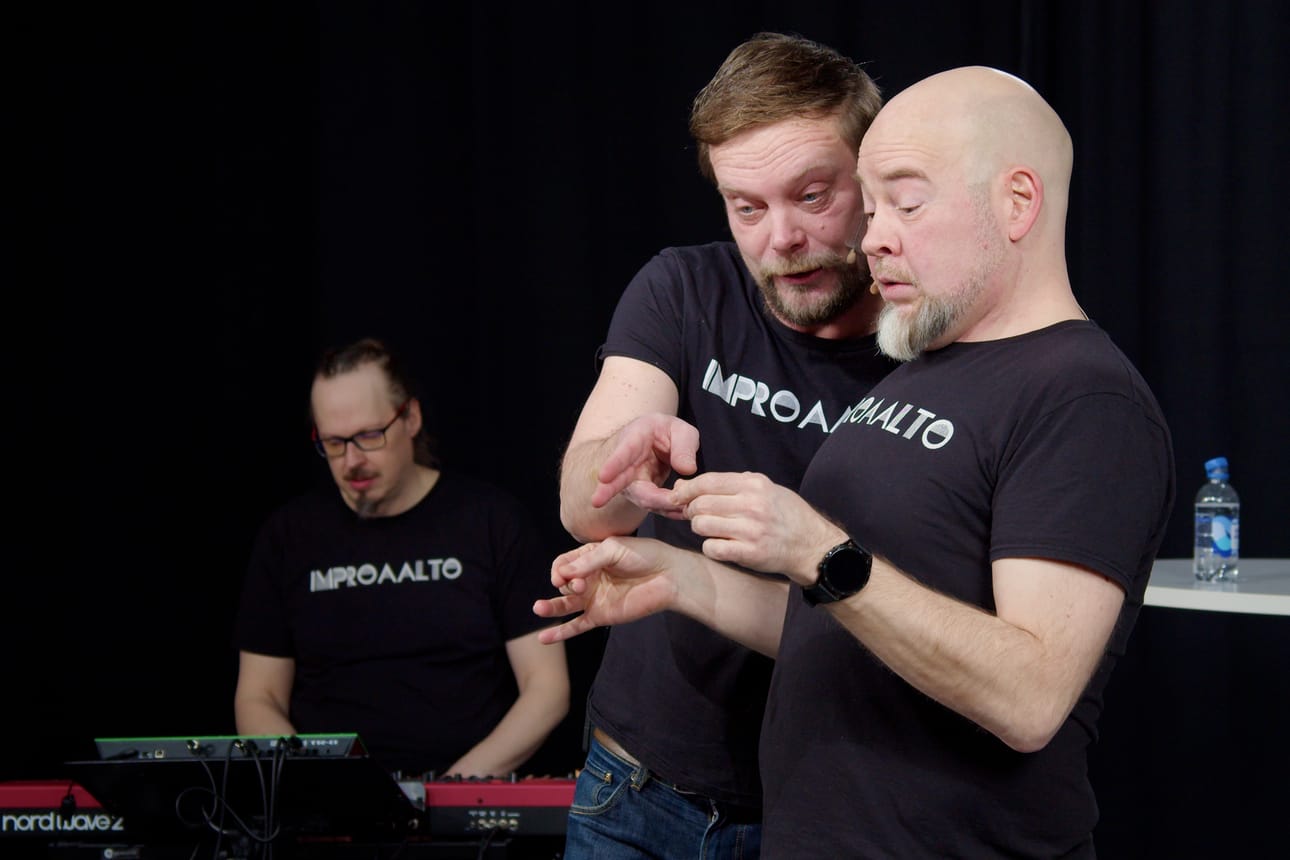Näyttelijät Rami Mäkilaine ja Tapani ”Tapsa” Korhonen Improaallon seitsemännessä jaksossa, taustalla Jaakko Elenius