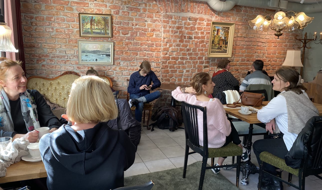 Pöydät ovat monesti täynnä. Seinillä on taidetta, jota asiakkaat ovat kahvilaan lainanneet.