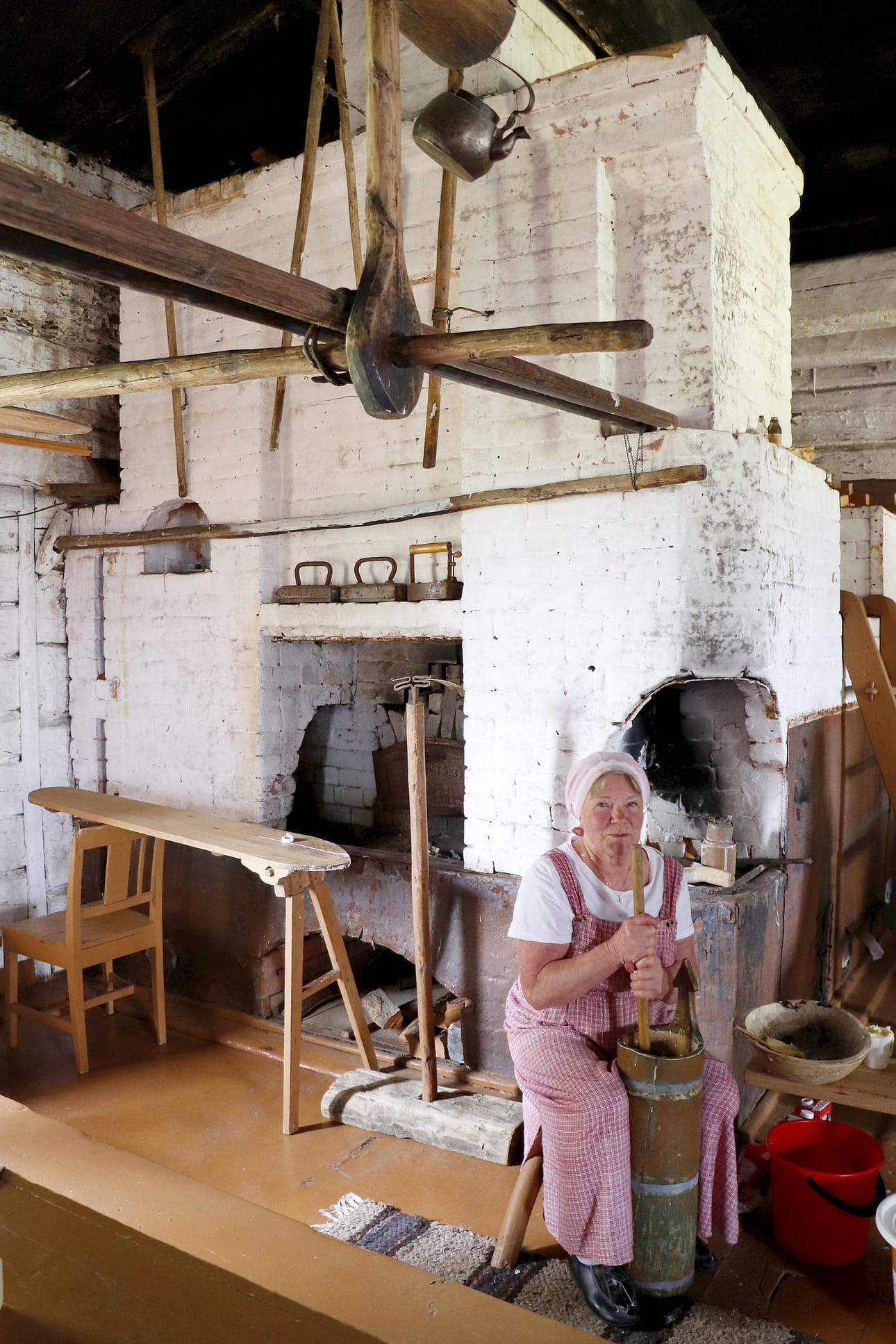 Sankalan Pirtin 18 leivän uunin edessä voita kirnusi Anja Jussila.