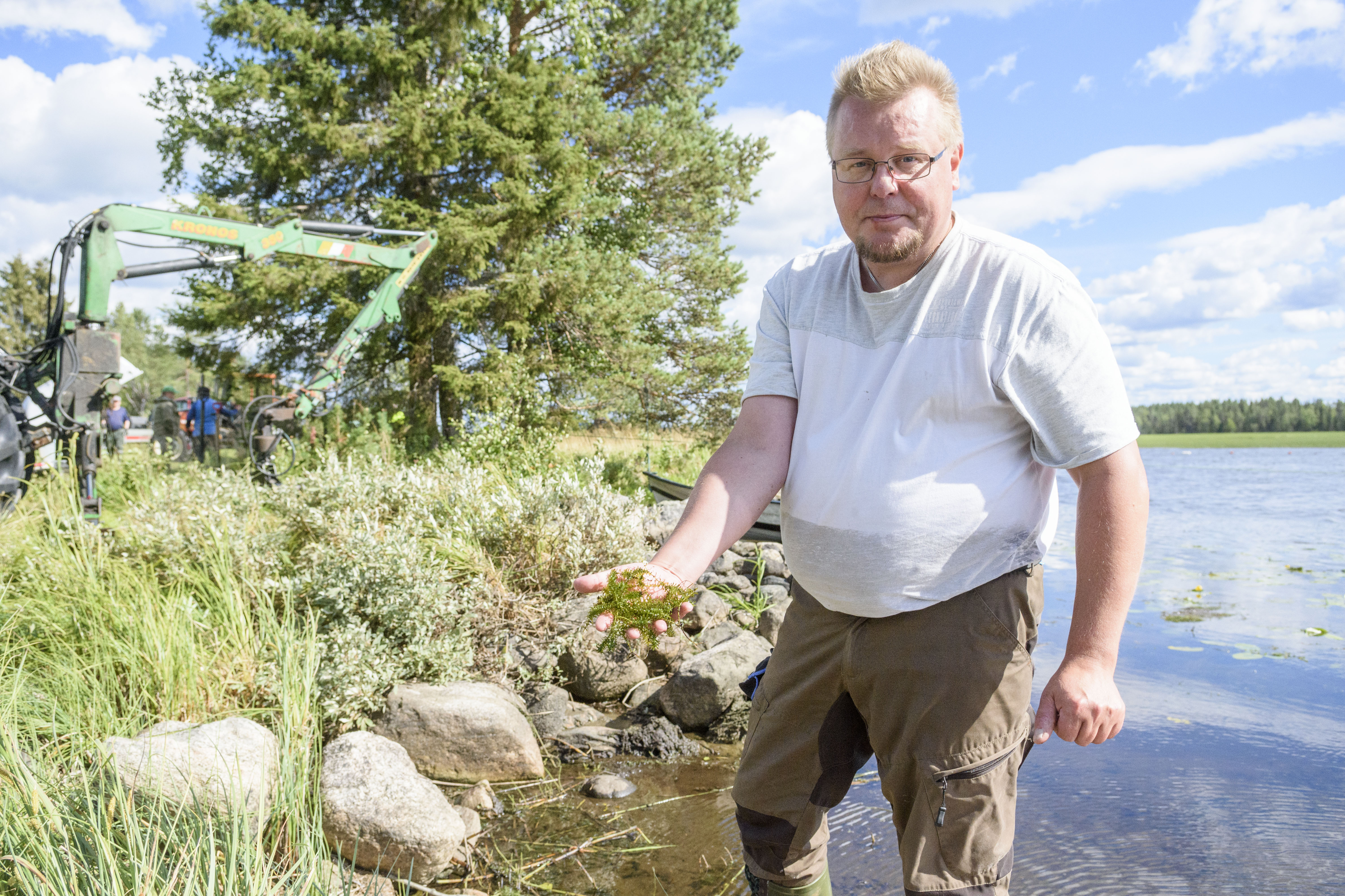 Heikki Tahkola piti kädessään vesiruttokasvustoa, jonka massasta suurin osa on vettä.