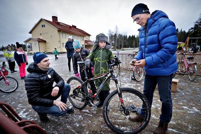 Isonkyrön kunnan hyvinvointijohtaja Antti Iivari (vas.) seurasi perjantaina, kun Valtaalan koulun opettaja Juha Hangassalo asensi valoja Viljami Ilveksen maastopyörään. KUVAT: TOMI KOSONEN
