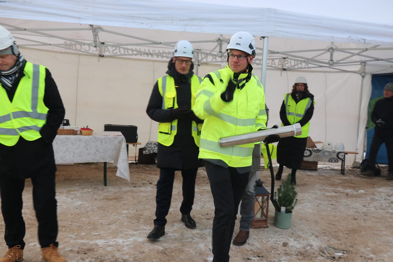 Tommi Sorvojan kädessä peruskiveen upotettu lieriö, jossa oli muun muassa päivän sanomalehdet, euroja ja juhlavan tilaisuuden ohjelma.