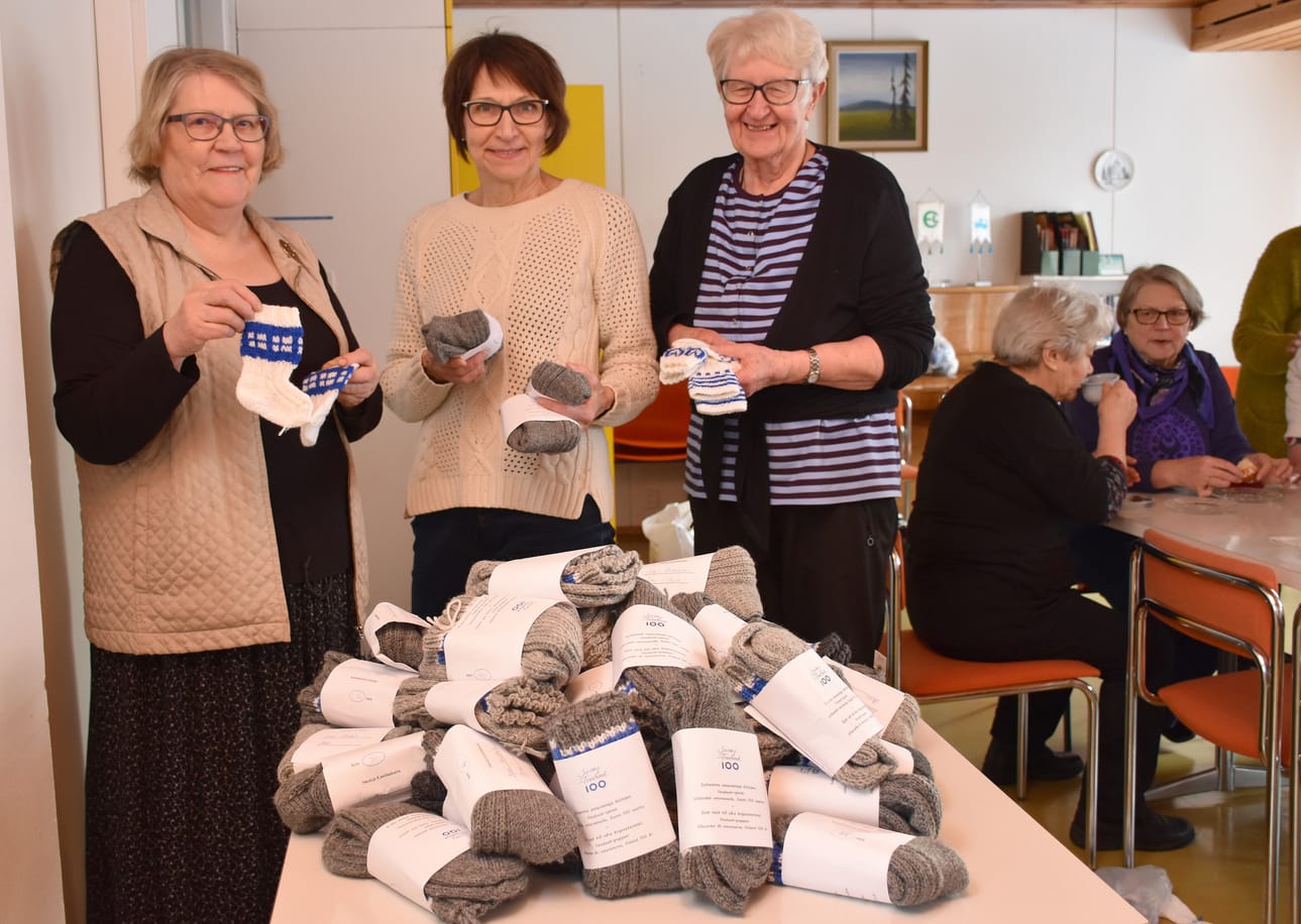 Tuula Karjalainen (vas.), Eija Kiviniemi ja Valma Tuppurainen esittelivät veteraaneille ja vauvoille kudottuja villasukkia