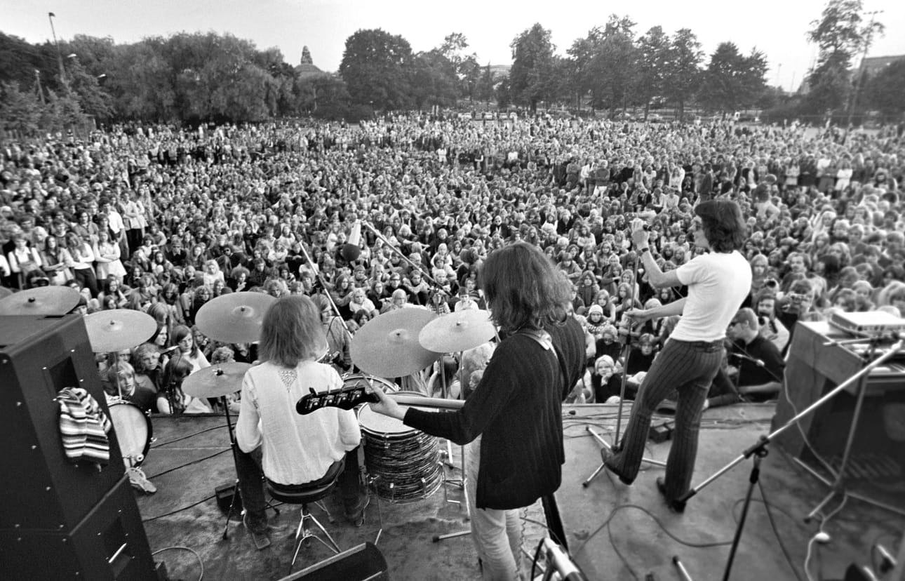 Wigwam lavalla Helsingin Kaisaniemen puistossa elokuussa 1970. Ronnie Österberg rummut, Pekka Pohjola basso ja Jim Pembroke laulu.