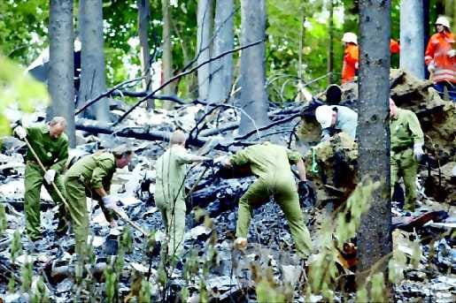 Tuhon jäljet . Saksalaiset poliisit ja palomiehet tutkivat päivän valjettua metsään pudonneen koneen jäännöksiä Owingenissä.