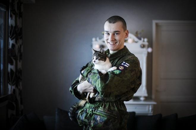 Alikersantti Juho Hannuksela vaihtaa armeijan lomapuvun joulunajaksi omiin siviilivaatteisiin. Taskulamppu-kissa viihtyy sotilaan sylissä. KUVA: KRISTA LUOMA