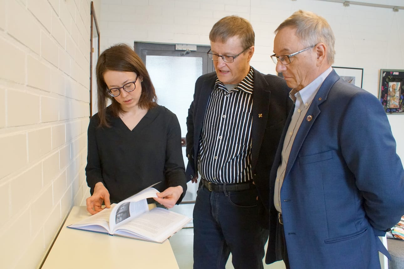 Paavo Ervasti ja Vesa Holmström luovuttivat kirjan kirjastonjohtaja Outi Nivakoskelle ja lainaajien käyttöön.