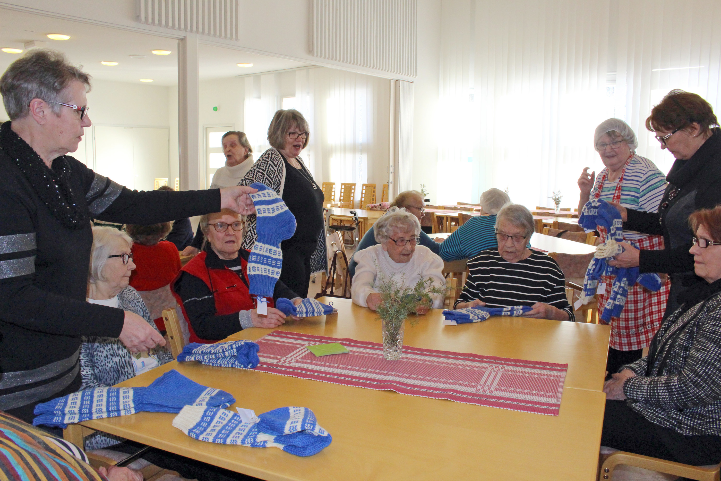 Myös veteraanien lesket saivat omat sukkansa. Sopivan kokoisia jakamassa mm. Alli Hämeenaho (vas.) ja Leena Räsänen.