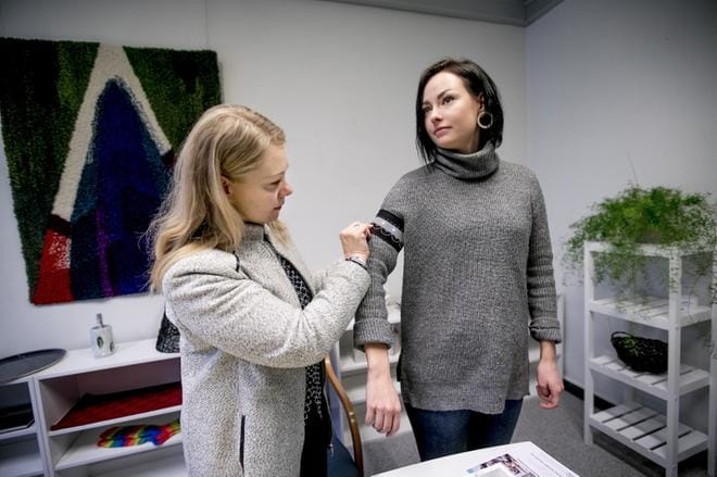Marja Hemminki-Haapoja kiinnittää ja Fiia Harju-Säntin käsivarteen elektroniikkaa sisältävän heijastimen. KUVAT: JAAKKO ELENIUS
