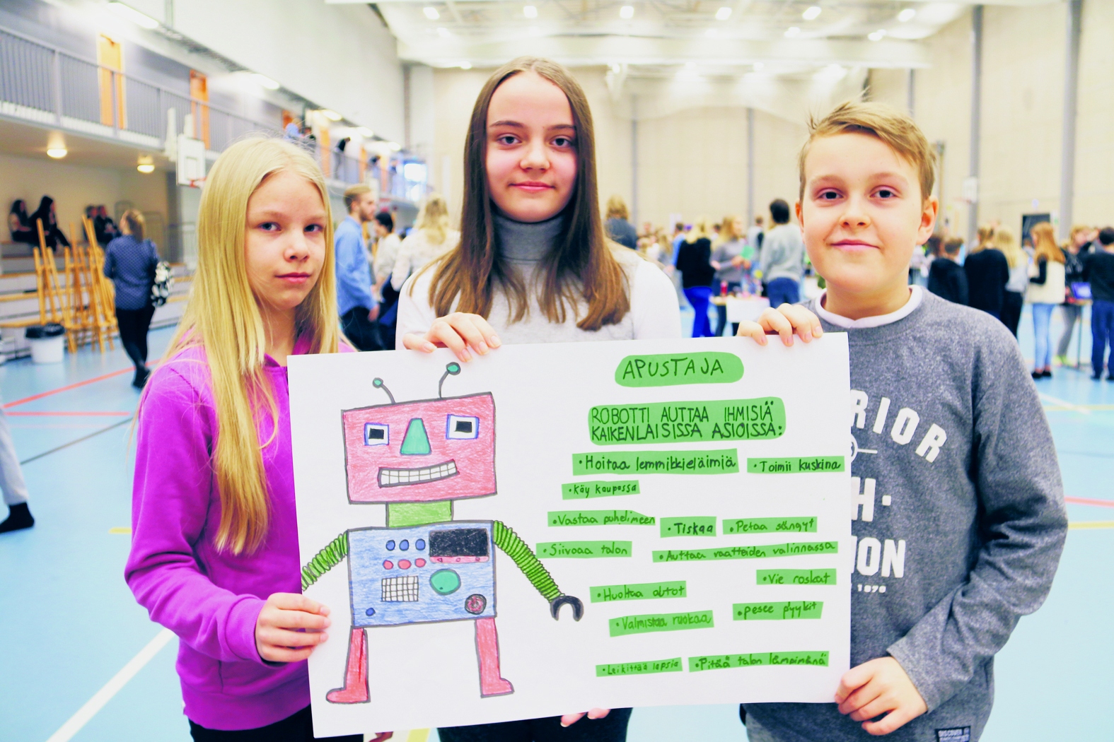 Ylikylän  Saana Penttilä (vasemmalla), Ella Isomäki ja Lenni Remes esittelivät muun muassa lapsia auttavan robotin piirustuksia.