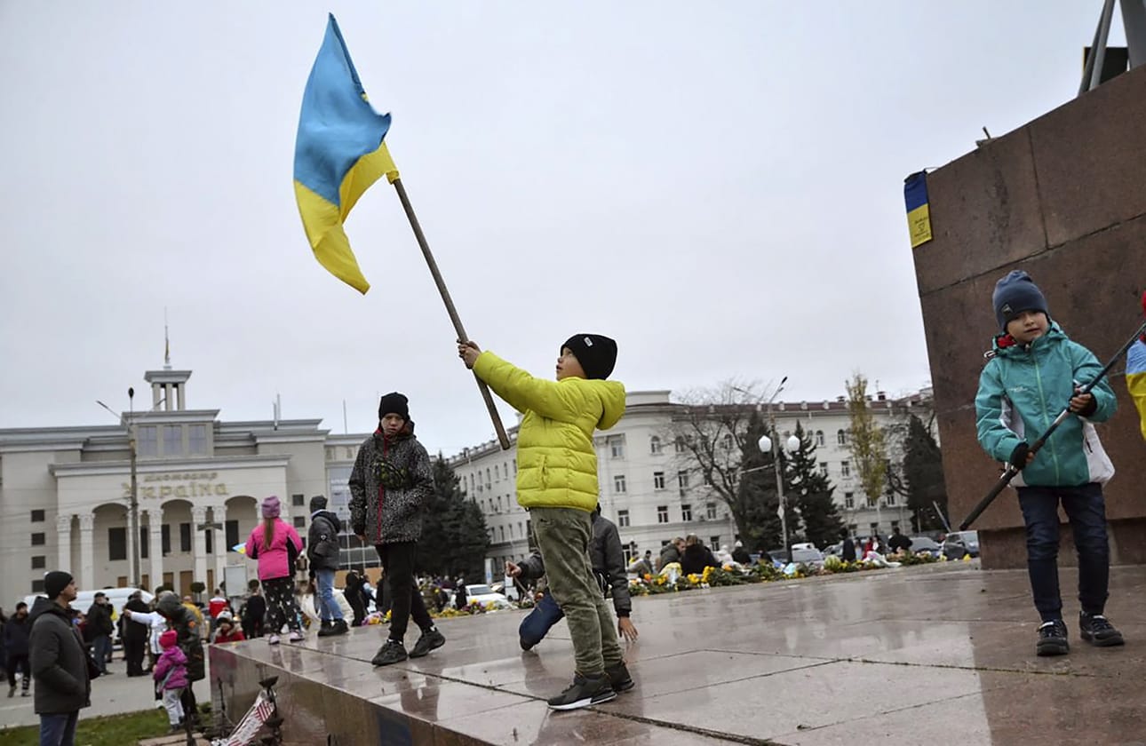 Lapsi heilutti Ukrainan lippua Hersonin keskusaukiolla sunnuntaina.