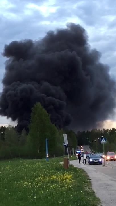 Musta savupilvi kohoaa palavasta ratapölkkypinosta
