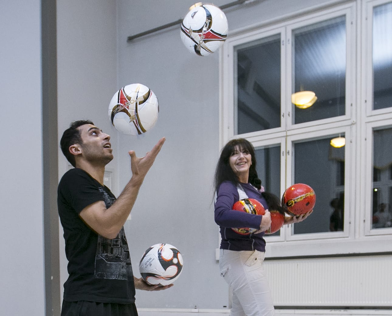 Entinen sirkustaiteilija Neli Rossi opettaa vapaaehtoisesti jalkapallojonglöörausta Päivärinteen hätämajoitusyksikössä Muhoksella.