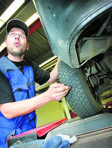 Oulun autokatsastuksen katsastusmies Mika Klasila tutkimassa renkaiden kuntoa.