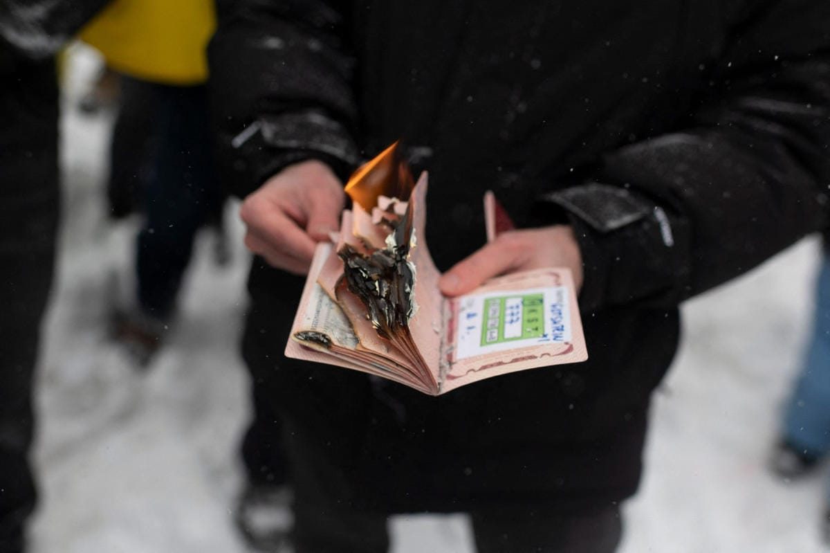 Mies polttaa Venäjän passiaan, kun ukrainalaisyhteisö protestoi Venäjää vastaan Kanadan Montrealissa Venäjän lähetystön edustalla 25. helmikuuta. Lehtikuva/AFP