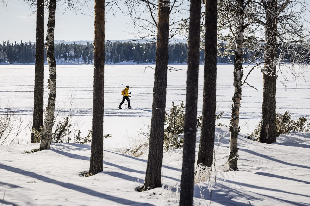 Keväisestä säästä nauttiva ulkoilija hiihtää Pyhäjärven jäällä Pelkosenniemellä.