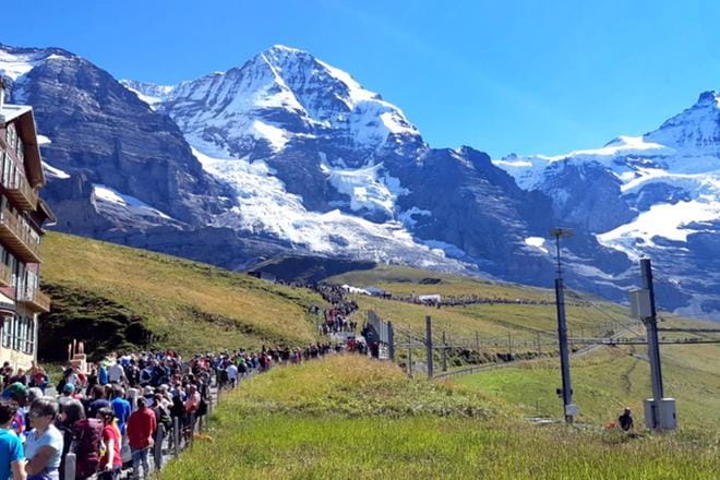 Maratonin maalialueella pienessä Kleine Scheidegg -kylässä oli yleisöä paljon. Juoksijat tulevat maaliin oikealta puolelta.