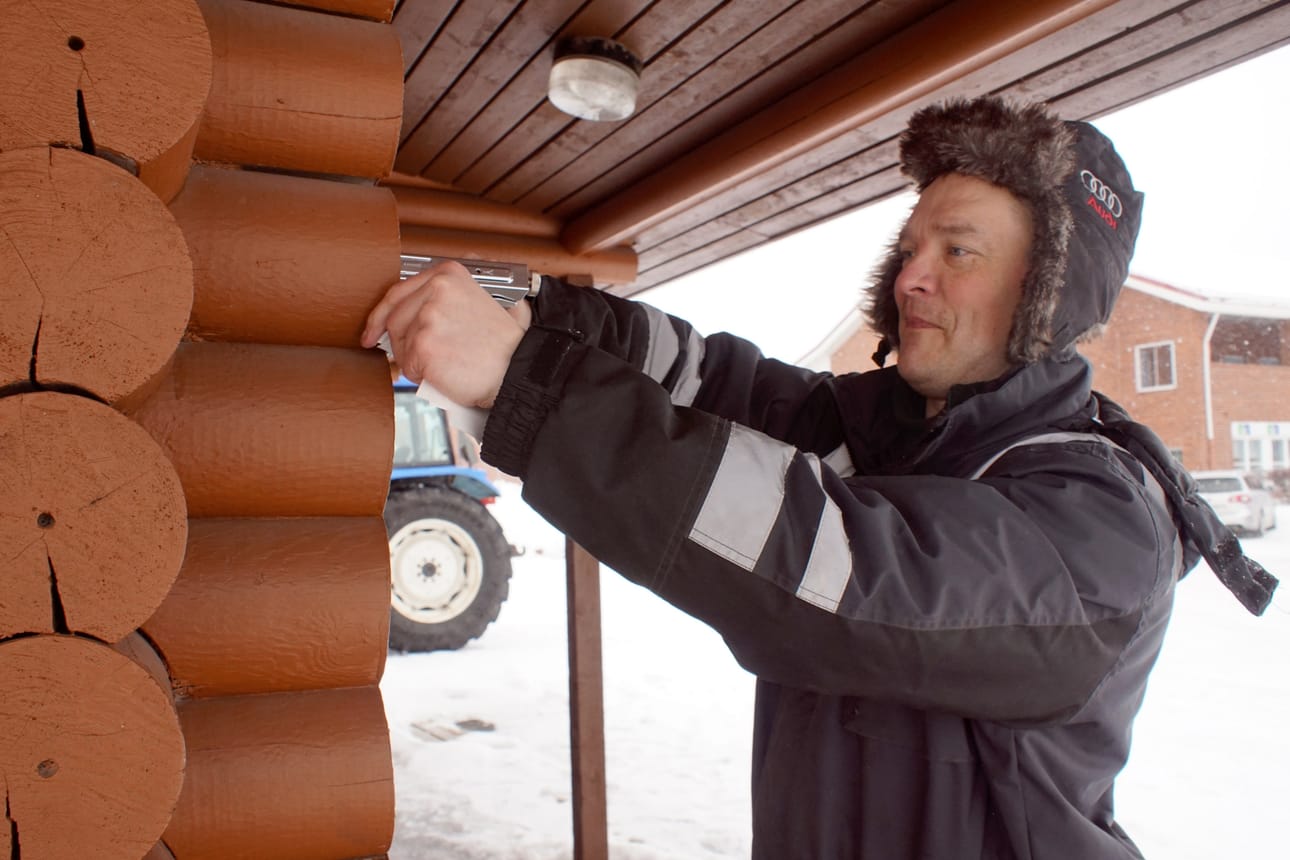 Hirsirakennuksen siirto alkaa hirsien merkitsemisellä. Juha Tenhunen naputteli ensitöikseen laput hirsien päihin. Nyt hirren on jo kuljetettu pois.