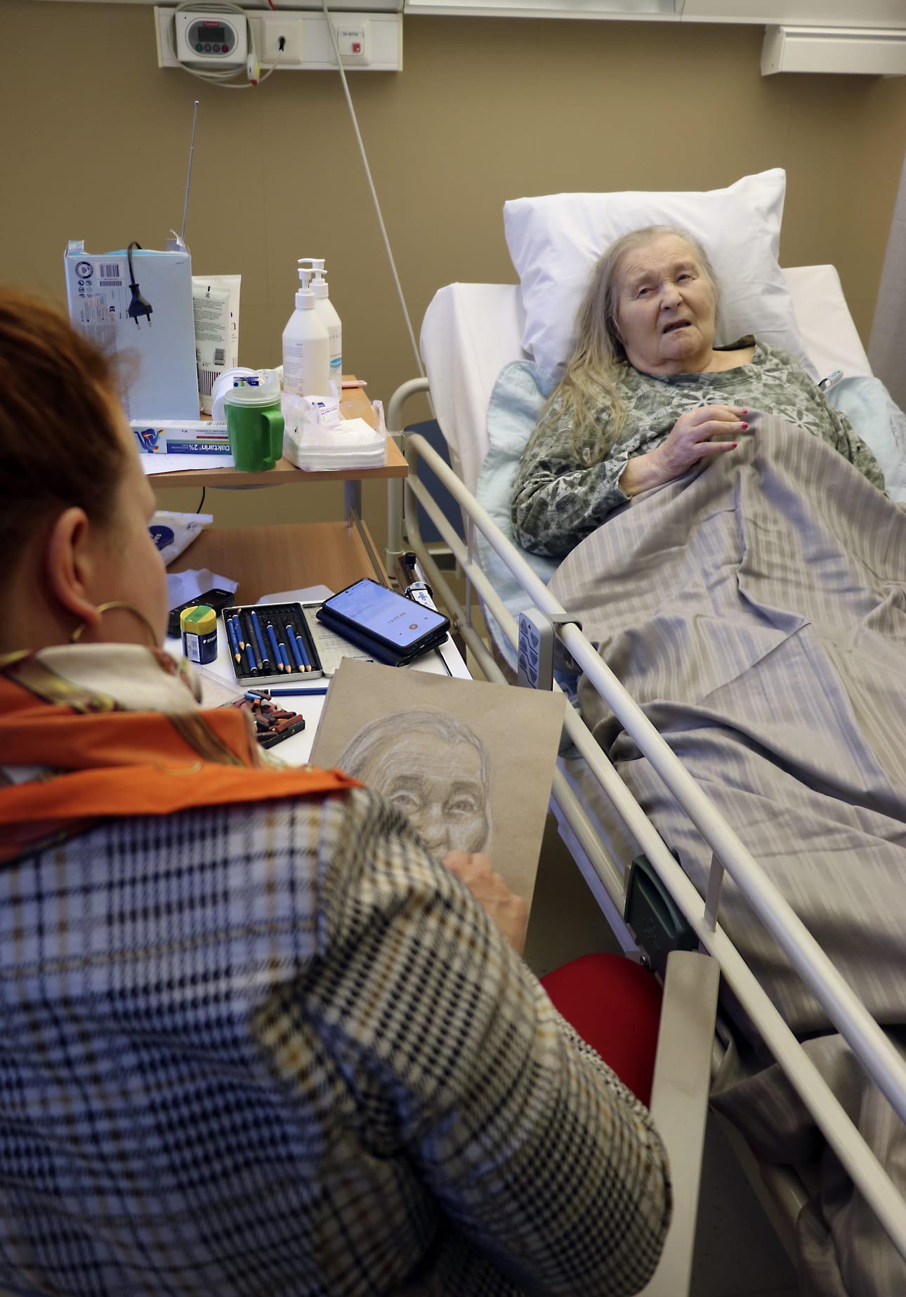 Oulaistelainen Aune Törmälä on yksi heistä, jotka ovat mukana kertomassa sota-ajan muistojaan taiteilija Jonna Taikatien taideprojektissa. Tarinoinnin lomassa Taikatie piirtää haastatelluista muotokuvat. (Kuvaus suoritettu osastolla omaisten ja hoitohenkilökunnan luvalla.)